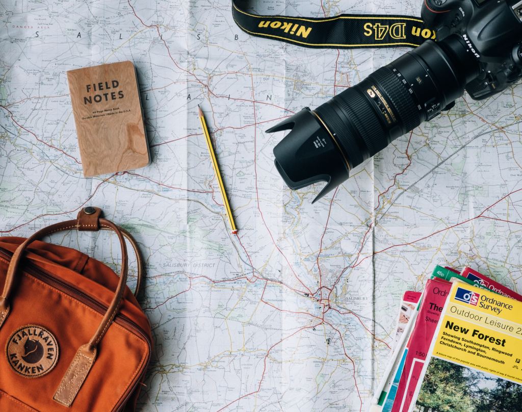 A map, camera, bag, pencil and notebook labelled 'field notes'